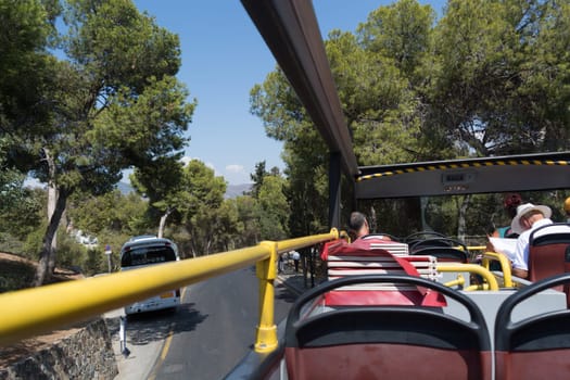 MALAGA, COSTA DEL SOL, SPAIN - AUGUST 31, 2019: Malaga, Costa del Sol, Spain - August 31, 2019: Tourist double-decker bus in Malaga, Spain. Red sightseeing bus with tourists on a sightseeing tour of Malaga.