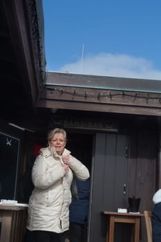 SYLT, GERMANY -MARCH  13, 2020: Sylt, Germany -March 13, 2020:  Woman at the Beach bar Sansibar, Kampen, Sylt, North Frisia, Schleswig-Holstein, Germany, Europe