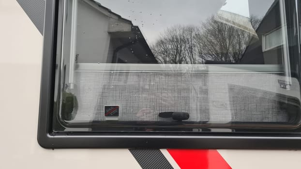 HEILIGENHAUS, NRW, GERMANY - FEBUARY 03, 2022: Heiligenhaus, North Rhine-Westphalia, December - February 03, 2022: Contact of an alarm system on the window of a caravan motorhome