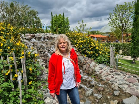 HEILIGENHAUS, NRW, GERMANY - JULY 15, 2020: Heiligenhaus, Nrw, Germany - July 15, 2020: Beautiful and Happy Woman In Front Of A Waterfall