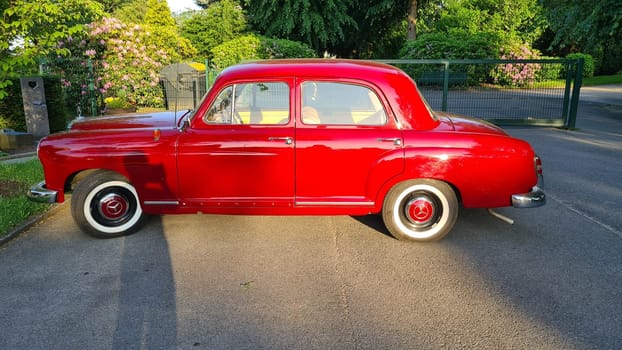 VELBERT, NRW, GERMANY - JUNE 14, 2021: Velbert, Nrw, Germany - June 14, 2021: A red mid-size luxury car Mercedes-Benz 180 (W120), 1955.