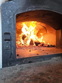 A close-up of a wood-fired oven with flames licking at the walls.