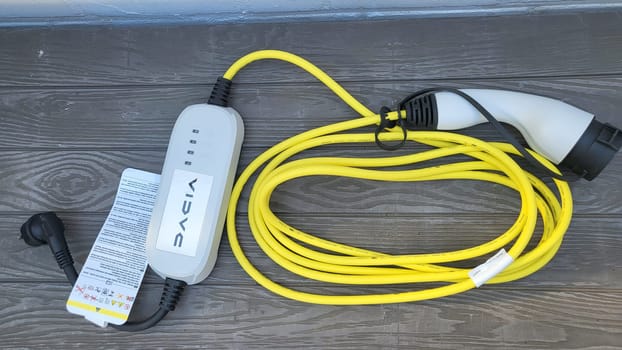 HEILIGENHAUS, NRW, GERMANY - AUGUST 16, 2022: Heiligenhaus, Nrw, Germany - August 16, 2022: Mobile charging station, wall box with yellow cable and Schuko plug for electric cars