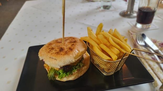 A juicy cheeseburger served on a sesame seed bun with a side of crispy golden fries.