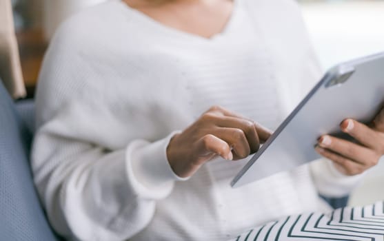 Closeup image of woman holding and using digital tablet, Working from home, checking news and information, learning new skills online.