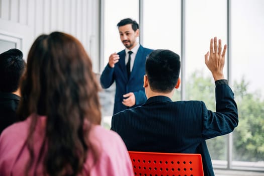 Group of business leaders presents their reviews in a meeting room, with a diverse audience of colleagues sitting, listening, and engaging. reflects essence of teamwork and productive discussions.