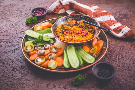 Spicy carrot spread, dip, hummus with raw snack vegetables