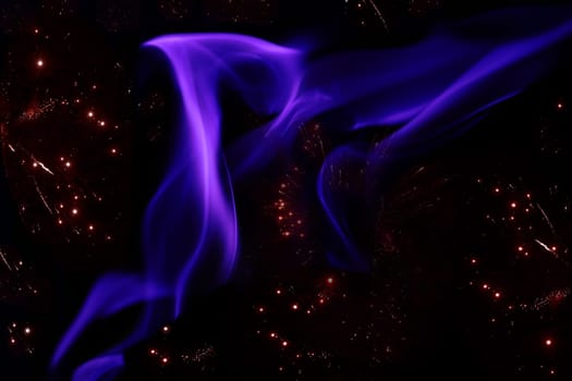 Flames, sparks and points of light in blue, purple and pink against a black background