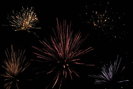 Turn of the year with various New Year's Eve rockets in the black sky