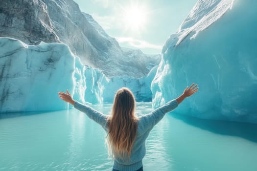 Blonde tourist embracing the landscape of nigardsbreen glacier in norway, with arms wide open