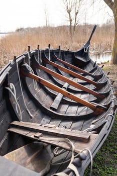 Detailed view of the interior of a Viking longboat, highlighting wooden ribs, ropes, and traditional construction techniques.