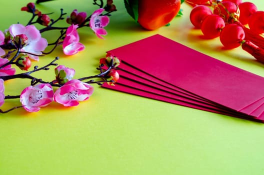 Chinese New Year decoration with red packets on yellow cover background with customizable space for text. Chinese New Year celebration concept.