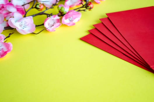 Chinese New Year decoration with red packets on yellow cover background with customizable space for text. Chinese New Year celebration.