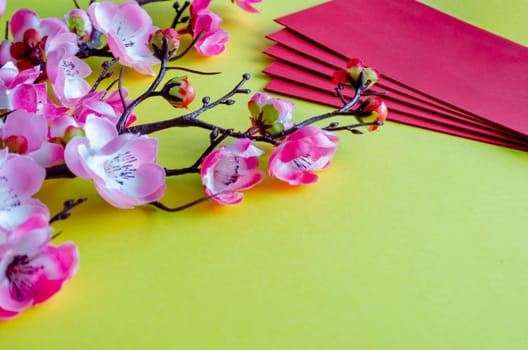 Side view of Chinese New Year decoration and red packets on yellow cover. Chinese New Year celebration concept.