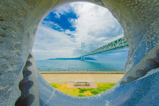 Akashi Kaikyo Bridge beyond the monument. Shooting Location: Akashi City, Hyogo Prefecture