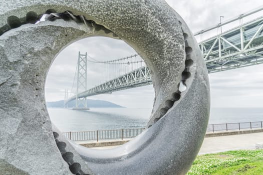 Akashi Kaikyo Bridge beyond the monument. Shooting Location: Akashi City, Hyogo Prefecture