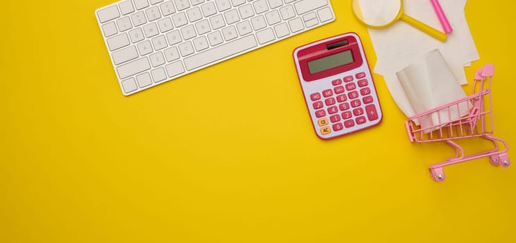 White wireless keyboard, stack of paper receipts and magnifier on yellow background, budget analysis concept, savings. Copy space