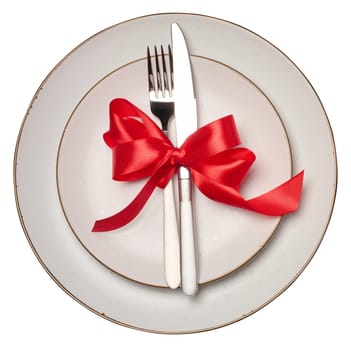 Empty white round plate, fork and knife on isolated background, top view