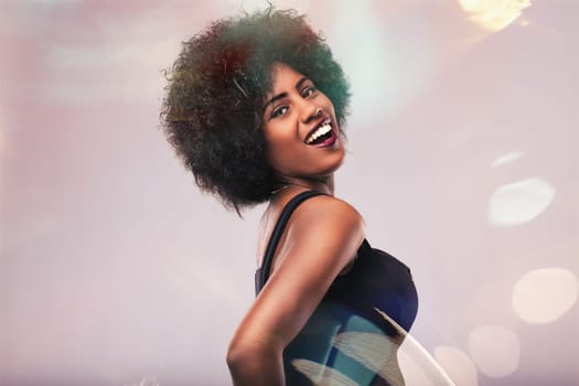 Young woman with beautiful afro hair smiling and dancing joyfully, surrounded by a vibrant bokeh effect in the background, capturing the essence of celebration and happiness