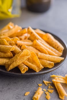 Rolled nachos tortilla chips on plate on a kitchen table.