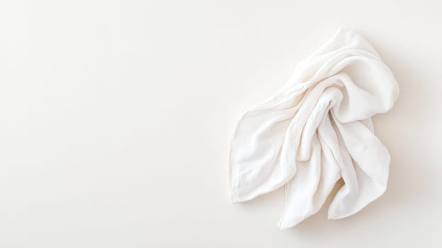 White cloth napkin is elegantly folded on a neutral background, creating a minimalist and stylish composition with ample copy space for text or design elements