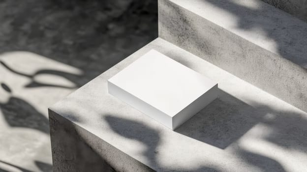 Sleek, minimalist white business card mockup is placed on a textured concrete step, bathed in sunlight and dappled with the shadows of leaves, creating a modern and sophisticated scene