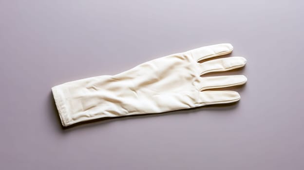 Single elegant cream colored glove rests on a simple, unadorned background, presenting a minimalist aesthetic with potential applications in fashion, accessories, or conceptual imagery