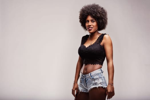 Beautiful latin american woman with an afro hairstyle radiates confidence and freedom, fully embracing her natural beauty and showcasing her unique, trendy style