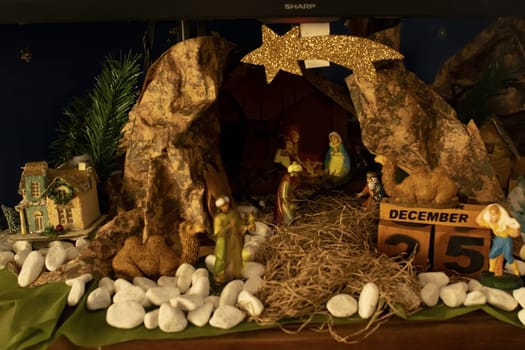 homemade nativity scene with Christmas lights and the date December 25 on wooden cubes