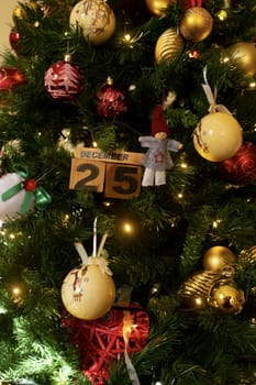 december 25 written on wooden cubes and photographed in the middle of christmas lights and decorations