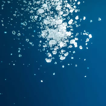 Coarse salt crystals falling against a dark blue background, creating a dynamic and textured visual with a minimalist aesthetic, ideal for food, cooking, or ingredient related concepts