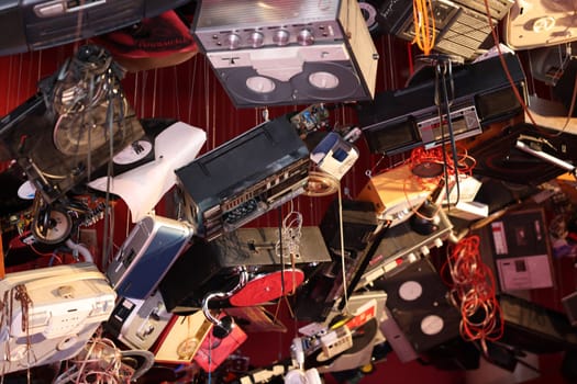 Venice, Italy - May 7 2024: Foreigners Everywhere 60th Venice Art Biennale. John Akomfrah, Listening All Night To The Rain at British Pavilion. Old video and audio players hanging from the ceiling of the red room.