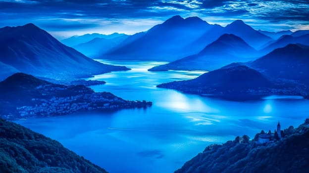 Tranquil mountain and lake scenery bathed in soft blue hues, featuring layered peaks, calm waters, and a small village nestled on the shoreline under a dramatic cloudy sky