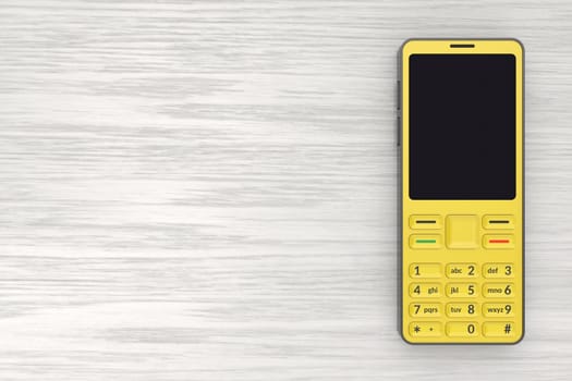 Yellow mobile phone with blank display on wooden desk, top view