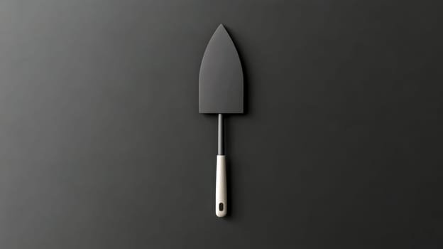 Black trowel with cream handle on a dark background symbolizing construction, masonry, and building trades, offering a minimalist and conceptual representation of tools and craftsmanship