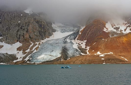 Glacier Cutting Through Colorful Mountains on a Foggy Morning in Brepollen, Hornsund in the Svalbard Islands
