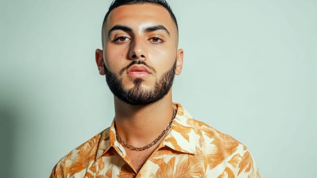 Studio portrait featuring a young man with a short beard, showcasing a trendy floral shirt and a silver necklace, radiating style and confidence in a modern setting
