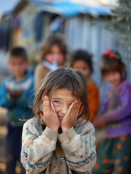 A distraught young girl covers her face with her hands, surrounded by a group of other children in a rustic setting. Her expression is one of fear and sadness
