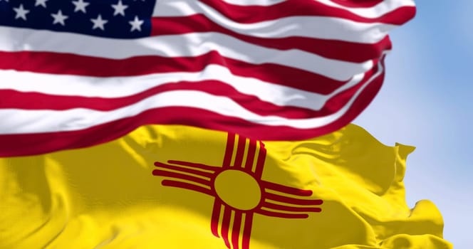 Close-up view of the New Mexico and United States flags waving in the wind on a clear day . 3d illustration render. Selective focus