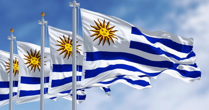 Uruguay national flags fluttering in the wind on a sunny day. Nine horizontal stripes: white and blue alternated, with Sol de Mayo in white square. 3d illustration render. Selective focus