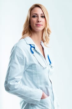Blonde woman in white lab coat, stethoscope around neck, hand in pocket. She's ready to deploy her vast expertise for her patients