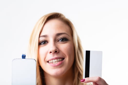 Happy blonde woman with smartphone, credit card for quick online shopping. Convenience in the digital world