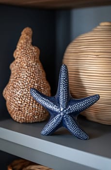A blue starfish sits prominently on a shelf next to textured natural decor pieces. The arrangement adds a coastal feel to the space.