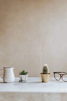 Small potted plants and a ceramic pitcher are arranged neatly on a table against a simple background, creating a serene atmosphere.