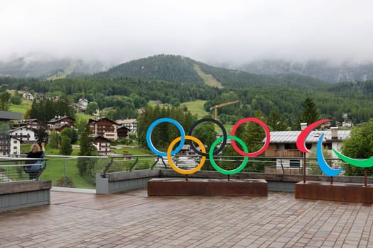 The Olympic rings in Cortina d Ampezzo against the background of the cloud-covered Dolomites. Italy