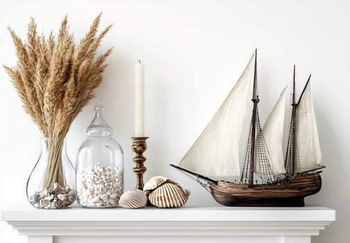A lovely arrangement features a model ship, decorative shells, a candle, and dried grass in vases on a clean white shelf.