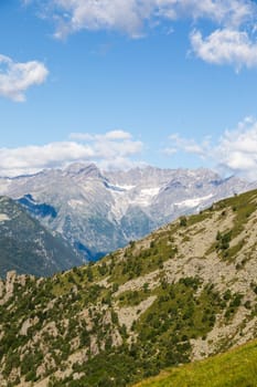Panorama of Italian Alps with blue sky and clouds. Calm landscape, tranquil scenic view.