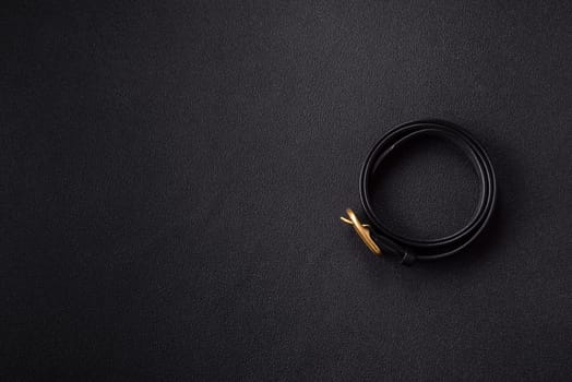 New leather women's belt with an old-style metal buckle on a dark concrete background