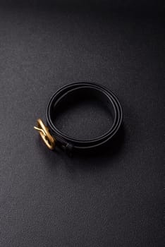New leather women's belt with an old-style metal buckle on a dark concrete background