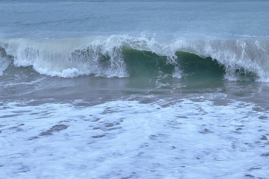 Detail of a wave breaking on the shore of the beach.Detail, waves. sea foam, turquoise colour, calm, emptiness, free space